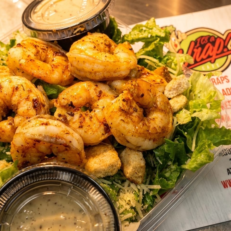 Grilled shrimp Caesar salad with croutons and dressing, next to an "It's a Wrap!" menu.